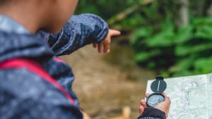 hiker using compass and map