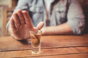 man declining a shot of alcohol